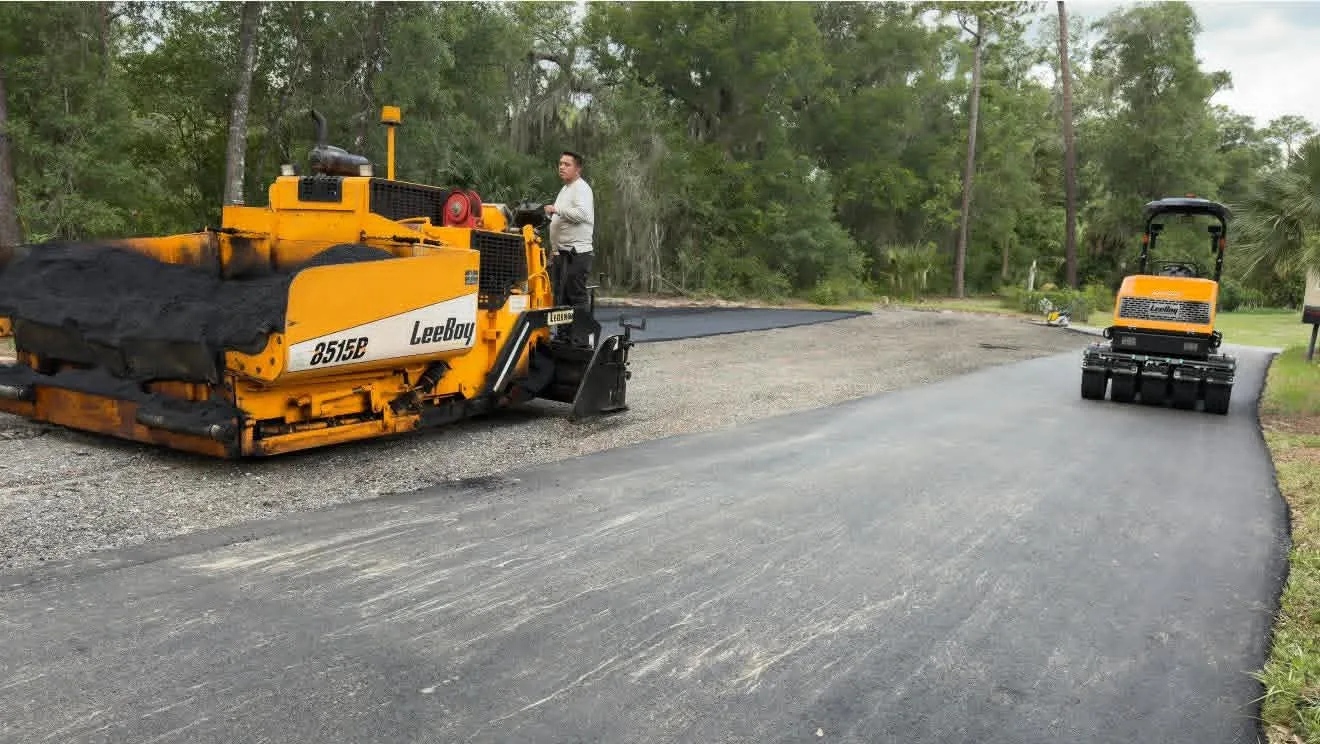 Paving crew working over a prepared gravel base before asphalt installation