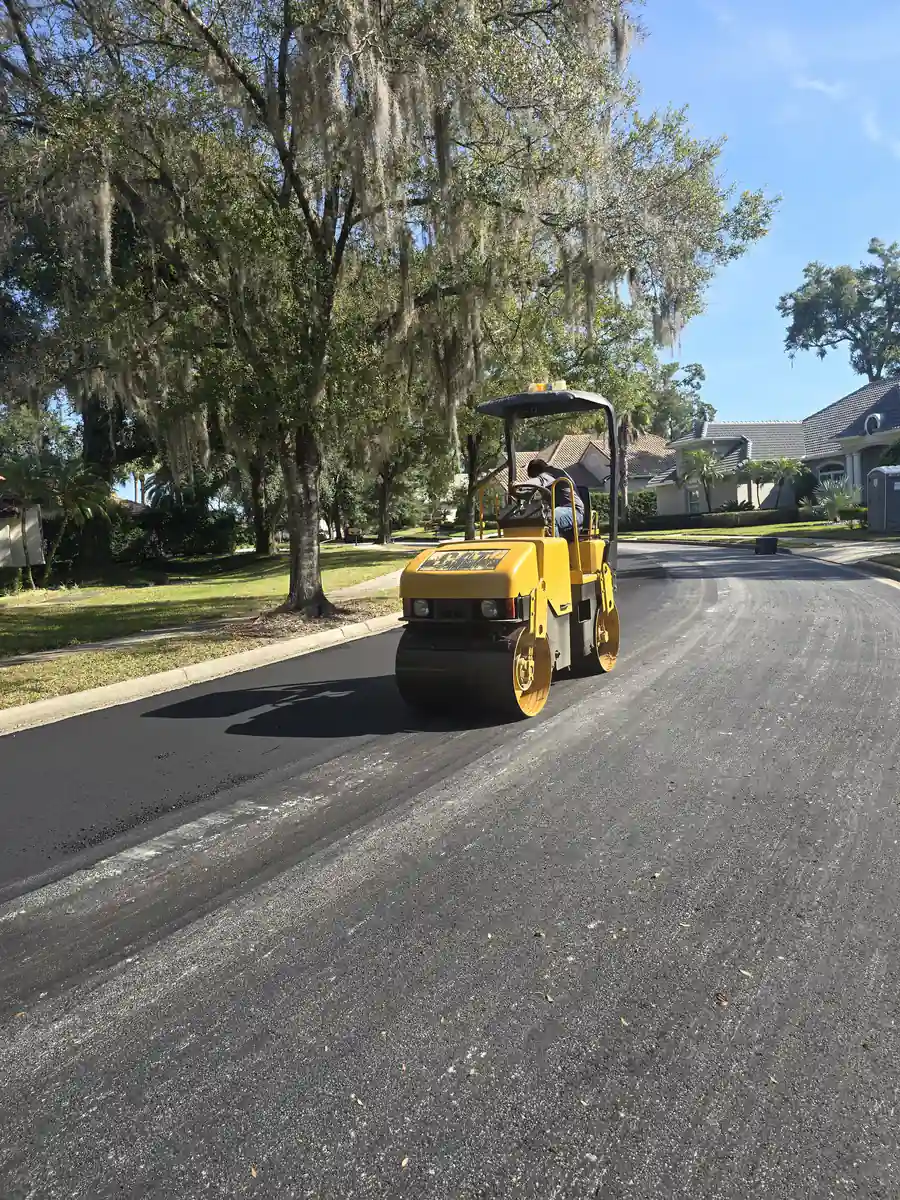 Tandem drum roller compacting a freshly laid asphalt lane on a residential street in Sanford, Florida