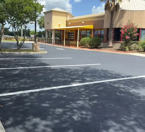 Resurfaced retail parking lot in DeLand, Florida with fresh stall striping