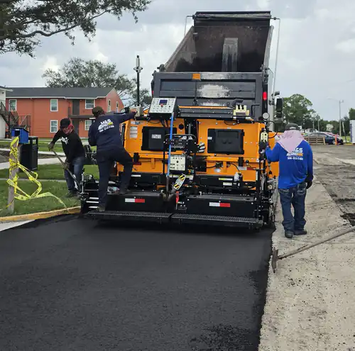 Paver laying one lane of asphalt with caution tape closing the work zone at an apartment complex parking lot in DeBary, Florida