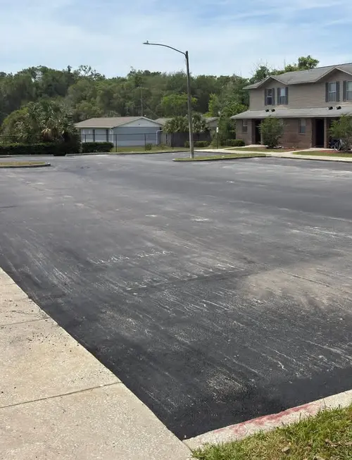 Finished townhome parking lot with new asphalt, concrete curbs and a concrete sidewalk