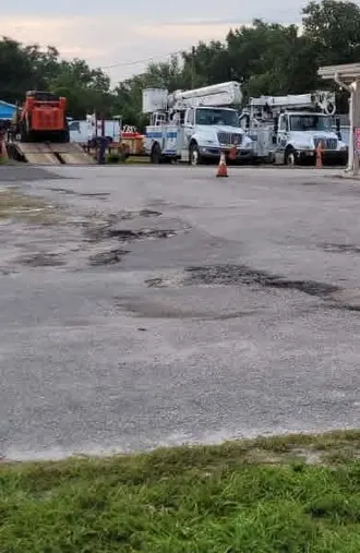 Commercial lot in DeLand, Florida with potholes and patched sections across the surface