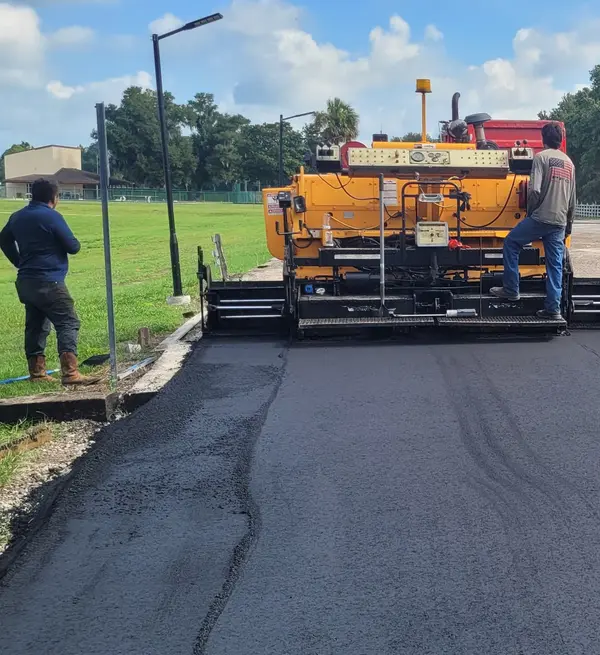 M&S Asphalt Paving crew running a paver over a freshly laid asphalt road