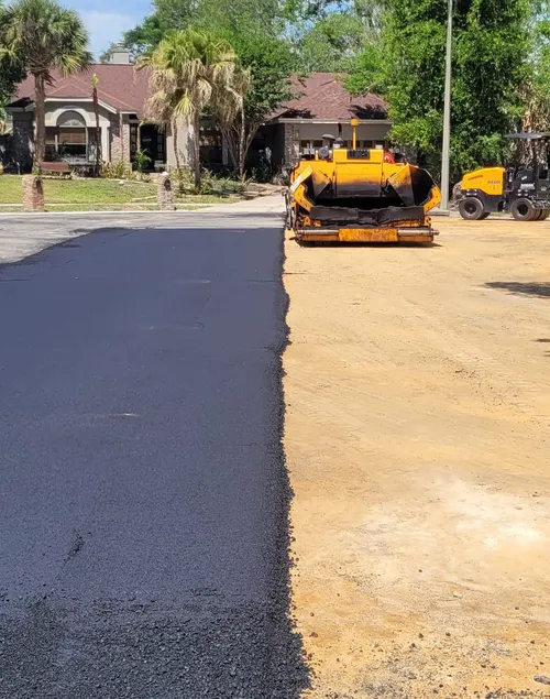 Paver laying a new asphalt driveway in front of a DeLand, Florida home