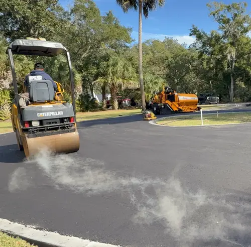 Freshly sealed residential turnaround in DeLand, Florida with the roller still on site