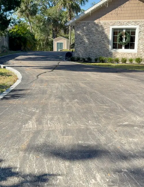 Long residential driveway running past a stone-faced home in DeLand, Florida